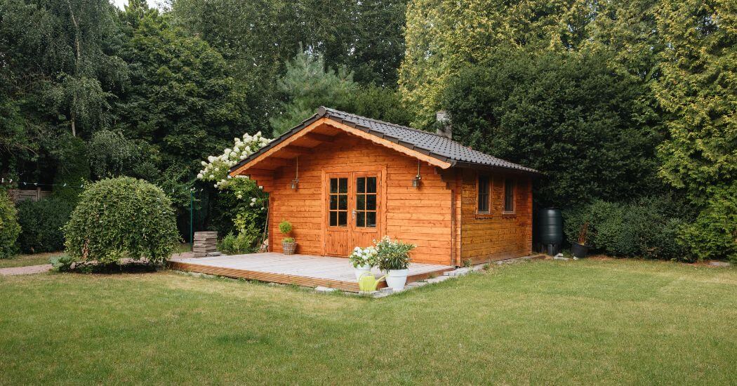 Ein gemütliches Gartenhaus umgeben von Natur, stellt die Unabhängigkeit und die Vorteile der Biotoilette von Biotioo dar. Für ein umweltbewusstes Leben und einfache Entsorgung.