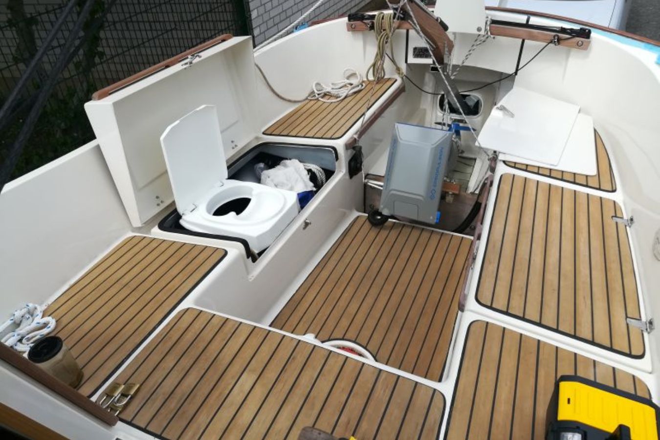 Das Foto zeigt eine Bordtoilette die in der Seitenbank auf einem Segelboot installiert wurde. Ein effizienter Umbau, der beim Reisen mehr Freiheit und Unabhängigkeit auf dem Wasser ermöglicht.