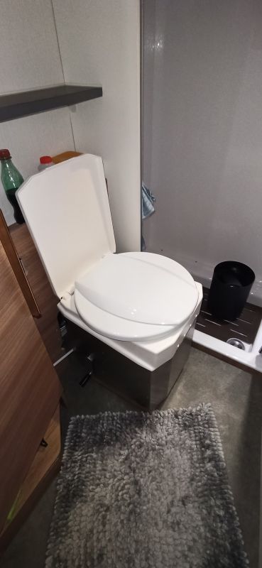 Das Bild zeigt den Eigenbau einer Drehkonsole für eine Trenntoilette. Die flexible Konstruktion ermöglicht eine platzsparende Nutzung und erhöht den Komfort im Camper durch einfache Anpassung der Position.