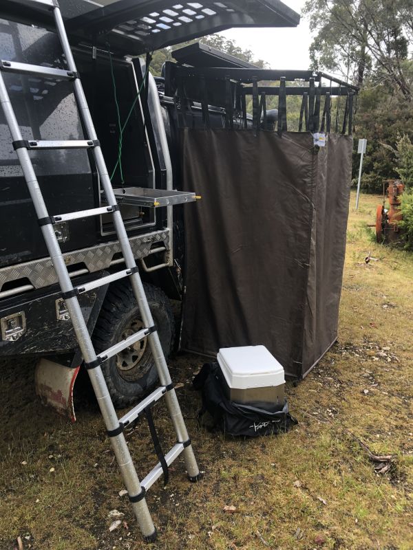 Das Bild zeigt die Verwendung einer Trockentoilette beim Camping mit einem Pickup-Aufbau. Die nachhaltige Lösung bietet Komfort und Unabhängigkeit für Reisen abseits klassischer Campingplätze und ist flexibel, sodass sie praktisch überall platziert werden kann.