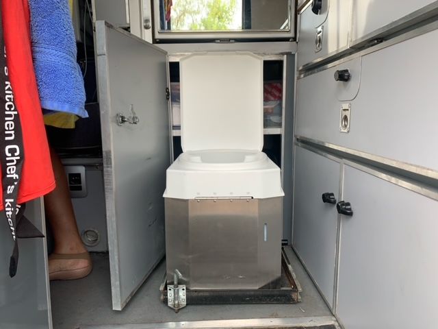 Das Bild zeigt eine Trenntoilette, die auf einem Schienensystem montiert wurde. Diese flexible Lösung ermöglicht eine platzsparende Nutzung und einfache Bewegung, ideal für kompakte Camper oder Spezialfahrzeuge.