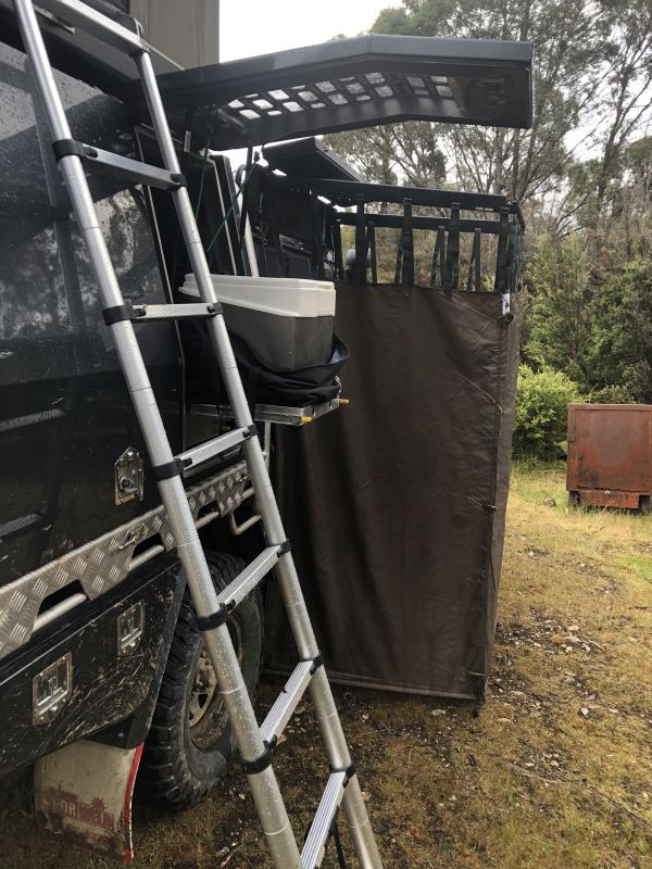 Das Bild zeigt die Verwendung einer Trockentoilette beim Camping mit einem Pickup-Aufbau. Die neue Lösung mit Trockentrenntoilette ist praktisch für unterwegs und bietet viele Vorteile zu herkömmlichen Modellen, die Umwelt und Natur belasten.